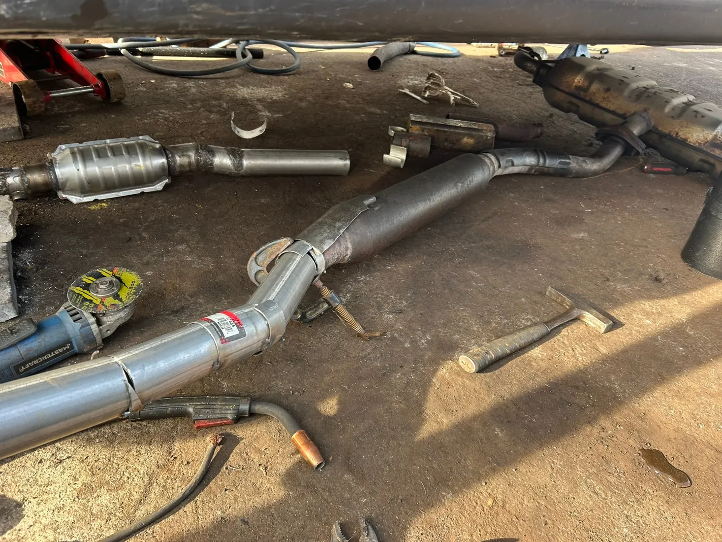 Real exhaust system repair with welded piping and catalytic converter on driveway